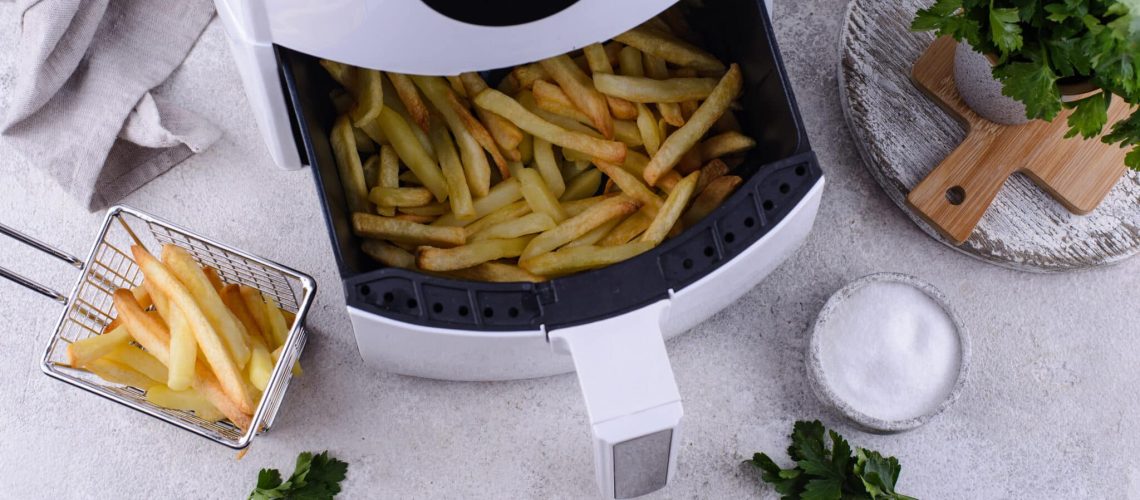 Patatine fritte cotte in friggitrice ad aria. Cibo sano e meno grasso